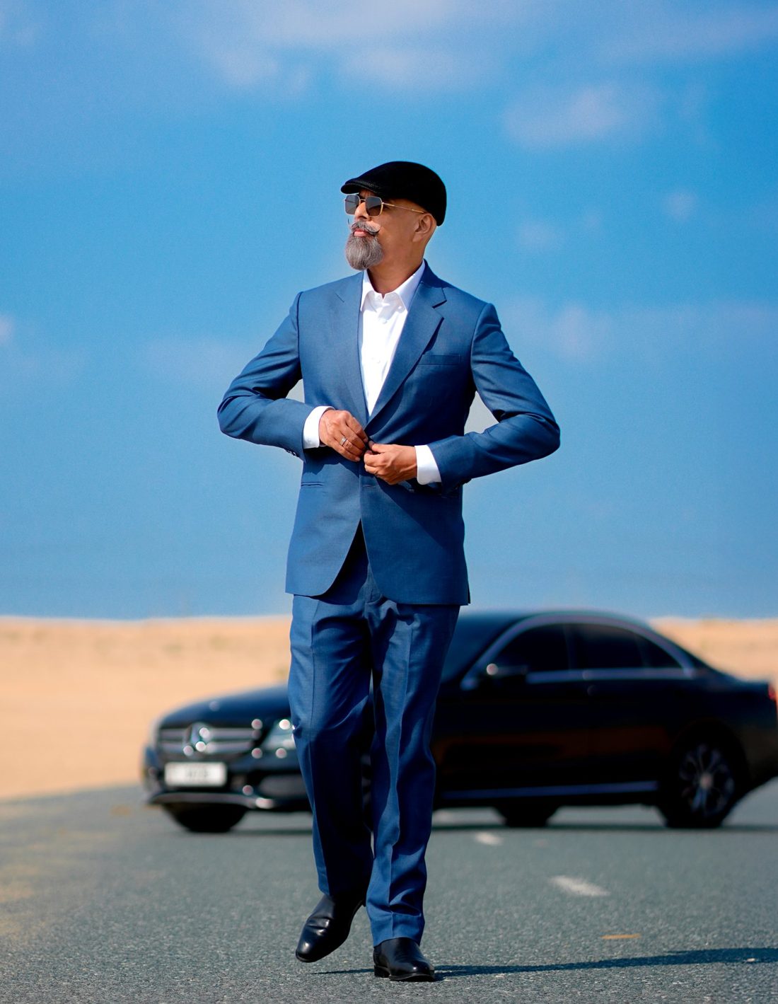 A client in a tailored blue Tex N Tailor suit, buttoning his jacket